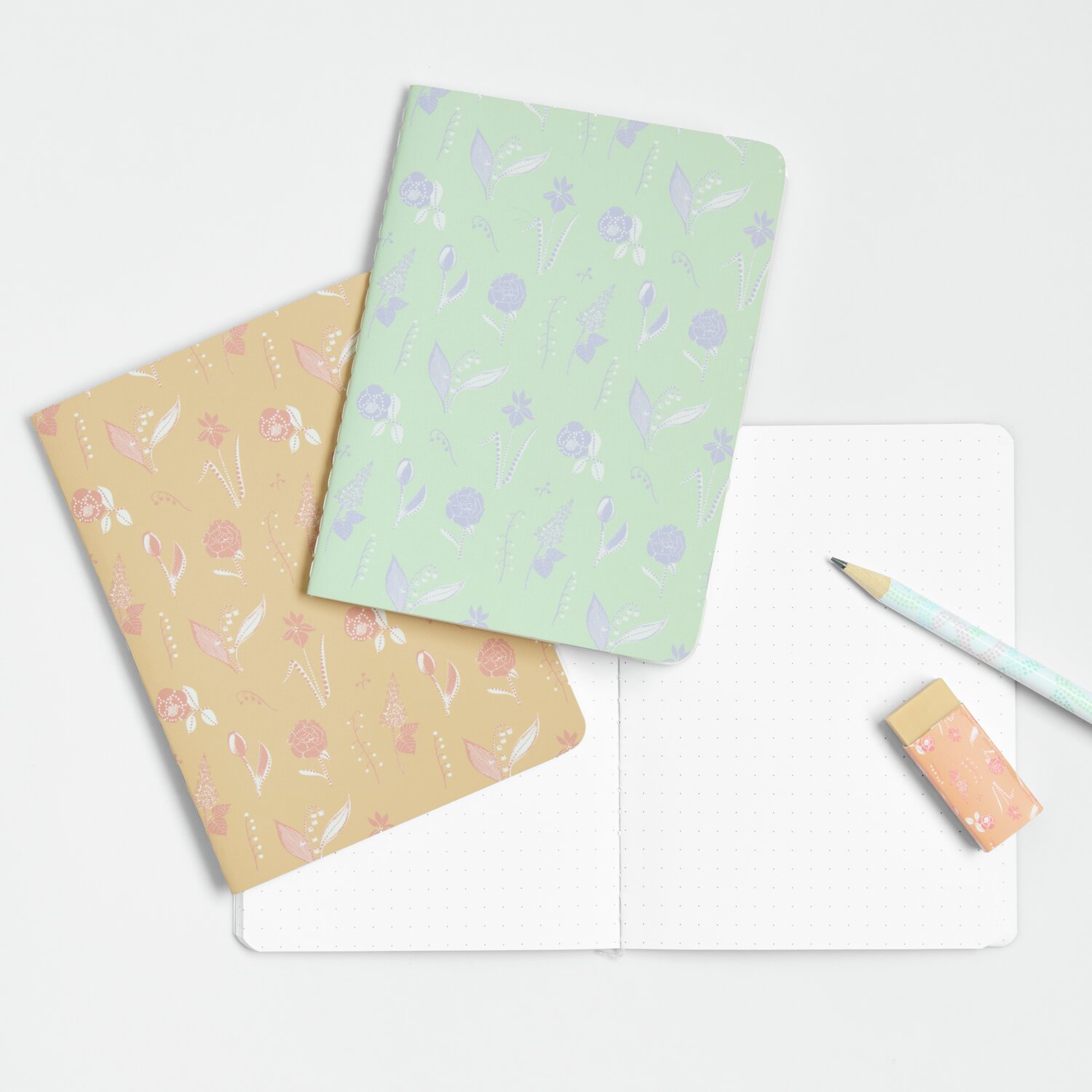 Notizhefte A6 Blumen Orange/Mint 2 Stück, mit floralem Design, Bleistift und Radiergummi.