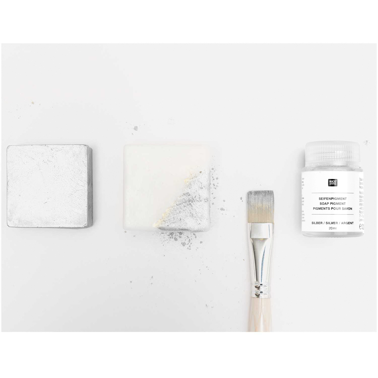 Seifenpigment silber, 20ml, von Rico Design. Silbernes Pigment neben Pinsel und bemaltem Seifenstück.