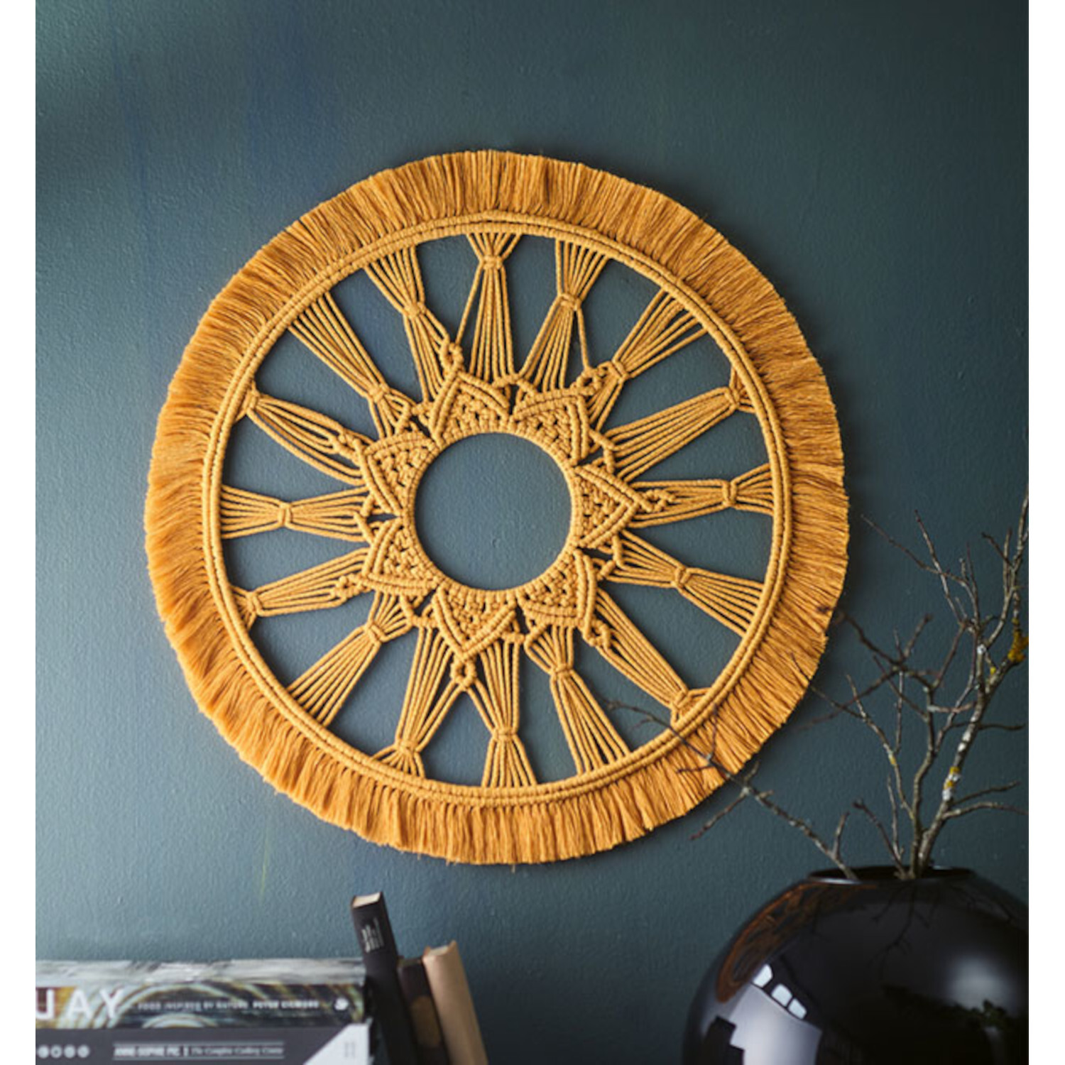 Mindful Mandala-Makramee: Gelbes Wanddekor aus geflochtenem Garn, kunstvoll an blauer Wand.