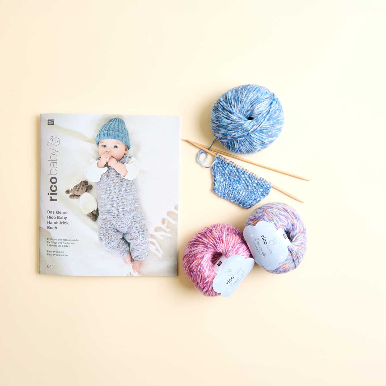 Baby 044 Heft mit 3 Wollknäuel und einem Strickstück auf Nadeln