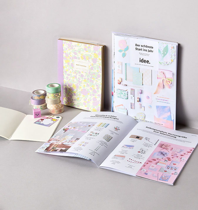 idee. Prospekt liegt in grauer Ecke mit Produkten daneben