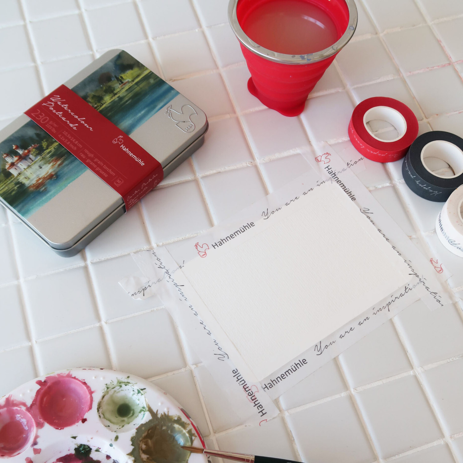 Masking Tape Set 4-teilig: Hahnemühle Klebeband umrahmt Papier auf weißem Tisch mit Malutensilien.