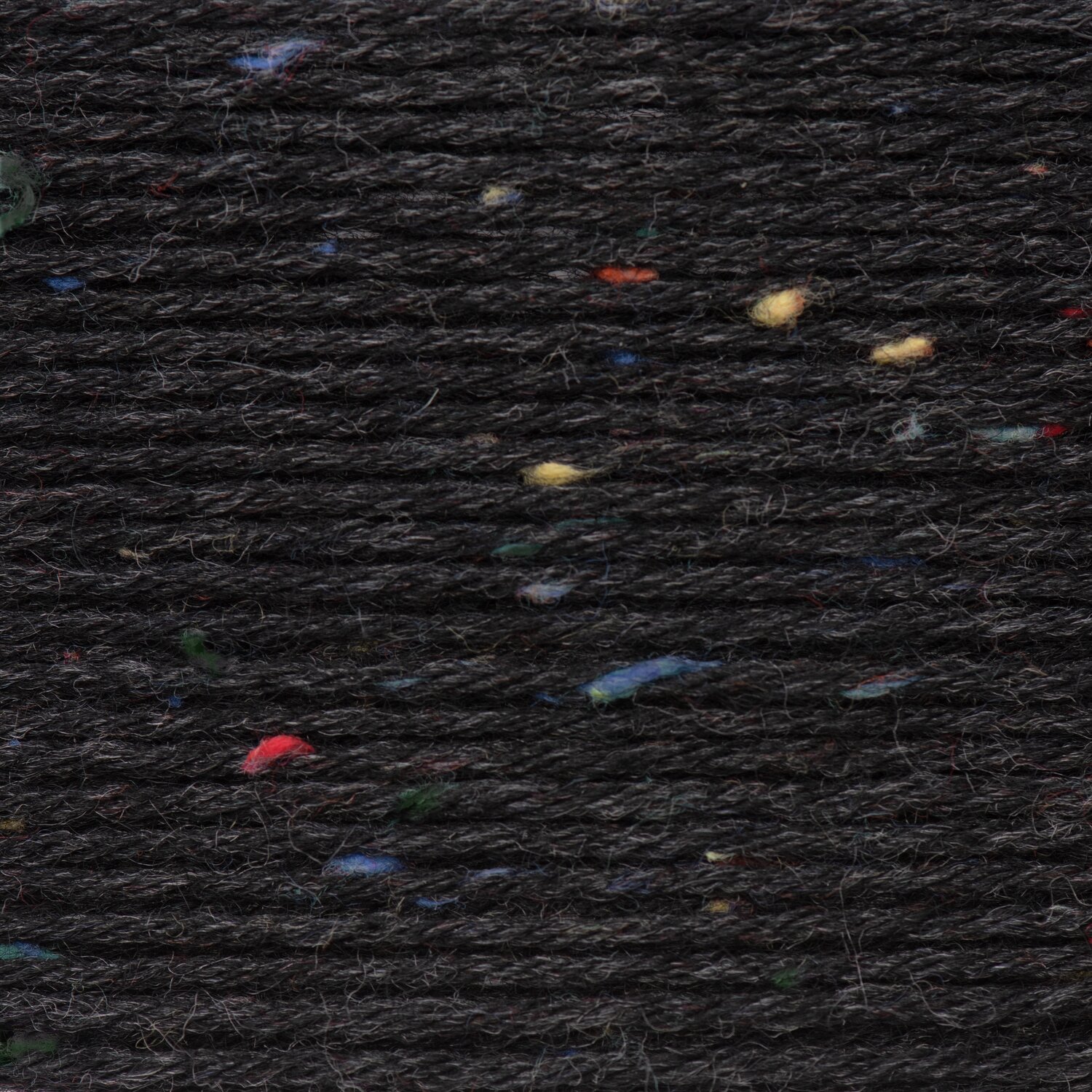 Superba Tweed 4-fädig: Hochwertiges Garn in dunklem Ton mit bunten Akzenten, ideal für Strickprojekte.